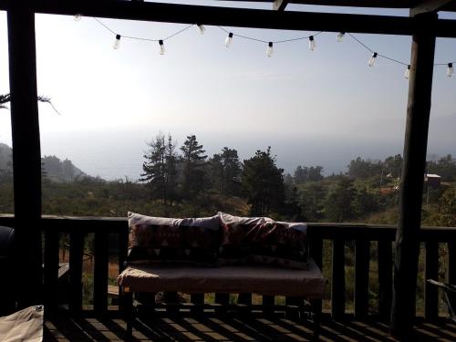 a couch on a porch with a view of the mountains at Cabaña en Laguna Verde in Laguna Verde