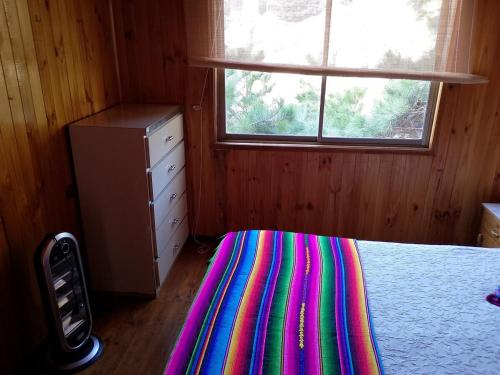 a bedroom with a bed with a colorful rug on the floor at Cabaña en Laguna Verde in Laguna Verde