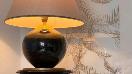 a black and yellow lamp sitting on a table at Relais du Dompeter in Molsheim