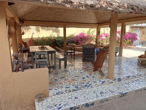 a house with a patio with a table and chairs at Chambre d'hôte Maryvonne & Mamadou in Nianing