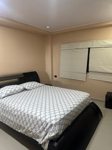 a bedroom with a bed and two windows at Jhonny Cay Collection Apartahotel in San Andrés