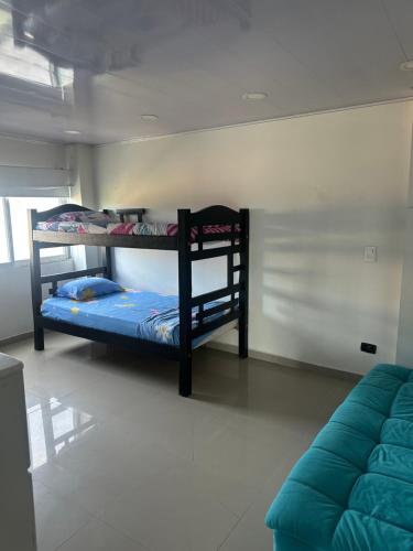 two bunk beds in a room with a couch at Jhonny Cay Collection Apartahotel in San Andrés