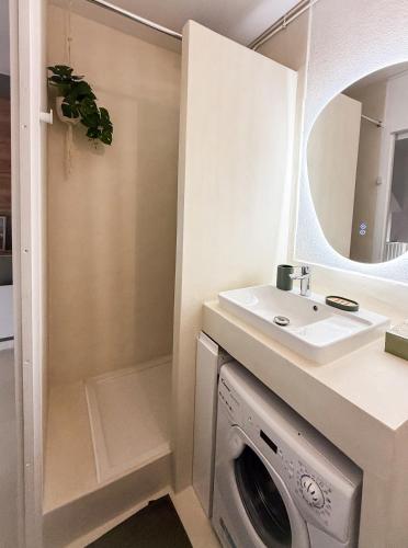 a bathroom with a washing machine and a sink at Duplex Cocon & Vue Mer Imprenable in Arcachon