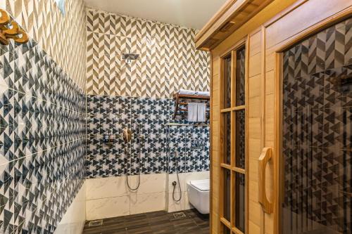 a bathroom with a shower and a toilet in it at Munal and Mayur Resort - Wellness Retreat Pvt Ltd in Tikoli