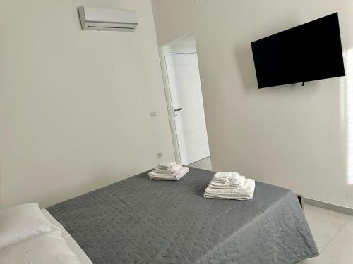 a bedroom with a bed and a flat screen tv at Levante Casa Vacanze in Torrenova