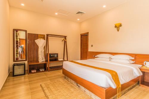 a bedroom with a large bed and a mirror at Munal and Mayur Resort - Wellness Retreat Pvt Ltd in Tikoli