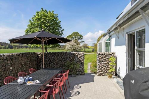 a wooden table and chairs with an umbrella at 40117-juelsminde-Gludvej-7 in Juelsminde