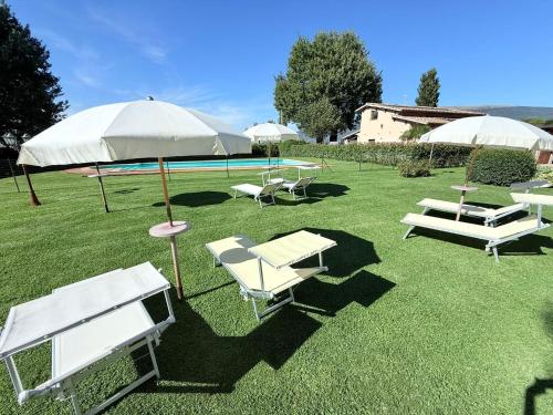 a group of lawn chairs and umbrellas and a pool at Fab villa with fenced pool, huge grounds, meditation park, child activity park in Limiti