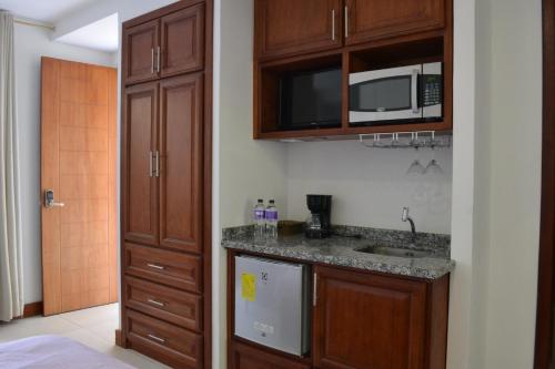 a kitchen with a sink and a microwave at Bamboo Village Place in Tumbaco