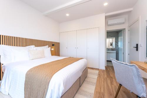 a bedroom with a large bed and a desk at Ápice - by Azores Green Villas in São Vicente Ferreira