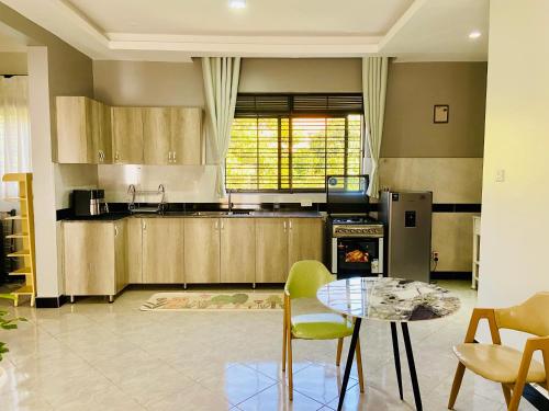 a kitchen with a table and chairs and a stove at Komie Stay Bunga in Kampala