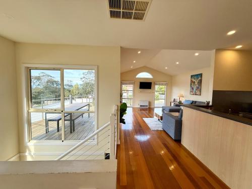 cocina y sala de estar con vistas a una terraza en Casablanca Beach House, en Torquay