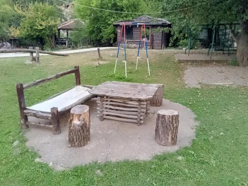 a playground with a wooden table and two logs at Etno selo Srna in Kalna
