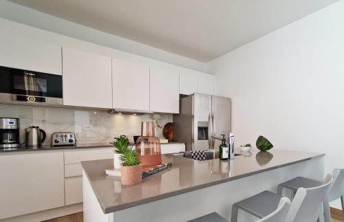 a kitchen with white cabinets and a counter at Tuscany Residence Aruba in Palm-Eagle Beach