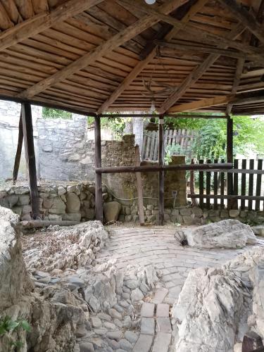 a building with a stone floor and a wooden roof at Etno selo Srna in Kalna