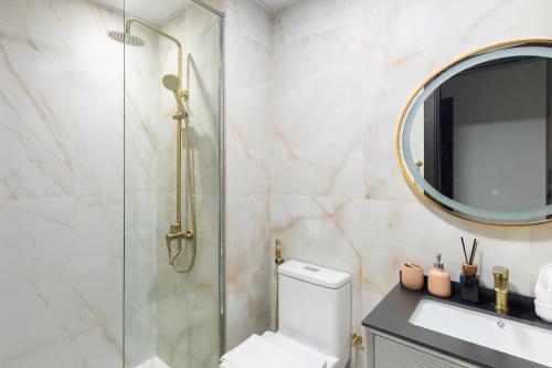 a bathroom with a shower and a toilet and a mirror at Simply Comfort Vacation Homes Rental Luxury 3Br Apts with Private Pool in Gemz in Dubai