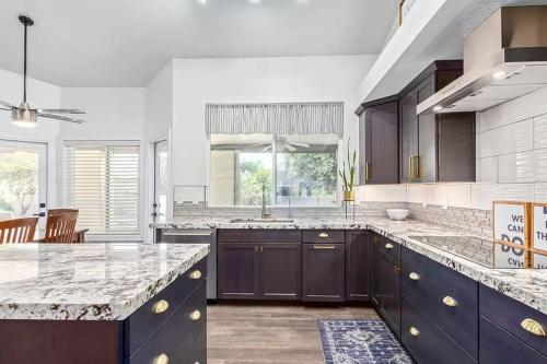 a kitchen with black cabinets and a counter top at Luxe Oasis! Pool, Mini-Golf, Games, Pets OK! in Mesa