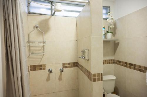 a bathroom with a shower with a toilet and a window at Los Cerezos Zona 9 - Templo SUD, CUNOC Y CEMACO in Quetzaltenango