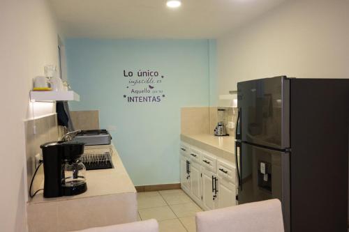 a kitchen with a black refrigerator and a counter at Los Cerezos Zona 9 - Templo SUD, CUNOC Y CEMACO in Quetzaltenango