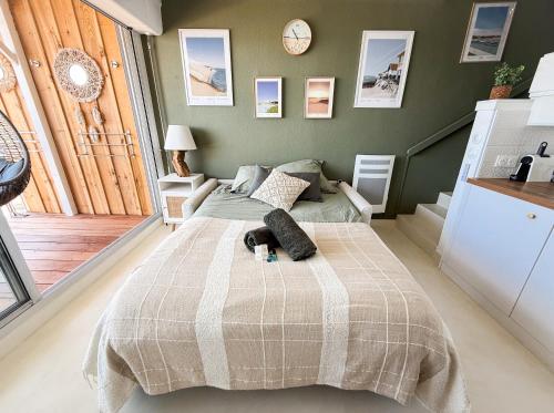 a bedroom with a bed with a blanket on it at Duplex Cocon & Vue Mer Imprenable in Arcachon
