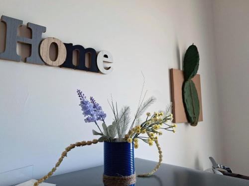 a blue vase with flowers on a table at Granatelli Holiday Home in Altavilla Milicia