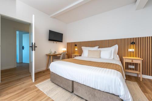 a bedroom with a large bed and a tv at Ápice - by Azores Green Villas in São Vicente Ferreira
