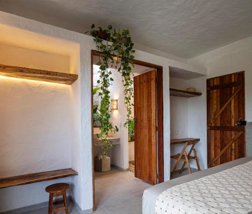 ein Schlafzimmer mit einem Bett und einer offenen Tür in der Unterkunft Casinha da Vila in São Gonçalo do Amarante