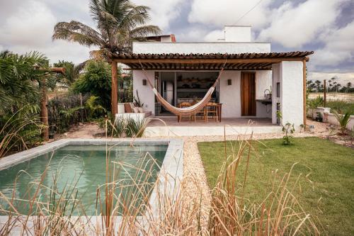 ein Haus mit einer Hängematte vor einem Hof in der Unterkunft Casinha da Vila in São Gonçalo do Amarante
