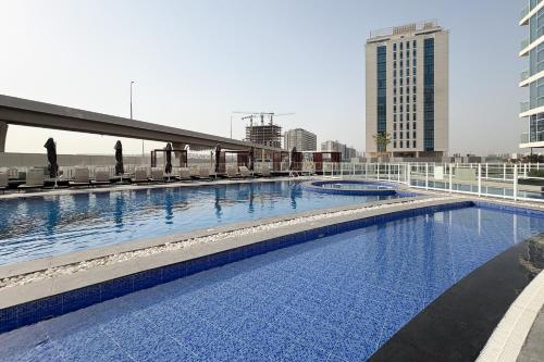 a large swimming pool on top of a building at Simply Comfort Vacation Homes Rental Luxury 3Br Apts with Private Pool in Gemz in Dubai
