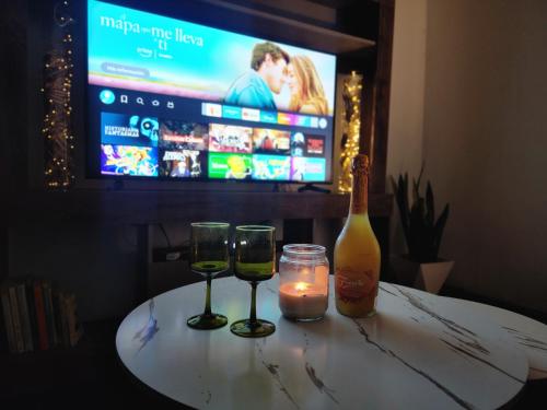 - une table avec deux verres, une bouteille et une bougie dans l'établissement Casa Monarca 0301, à Comayagua
