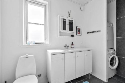 a white bathroom with a toilet and a sink at 40385-Juelsminde-Firkanten-5 in Sønderby