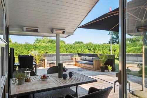 a patio with a table and chairs and a couch at 40146-Juelsminde-Elmealle-24 in Juelsminde