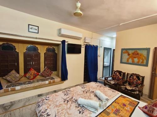 Un dormitorio con una cama, un sofá y un televisor. en Incredible's Hostel & Safari, en Jaisalmer