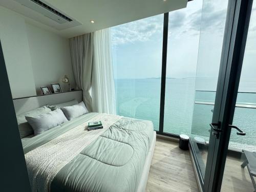 Un dormitorio con una cama y una ventana grande. en Arom Wongamart by David Home, en Norte de Pattaya