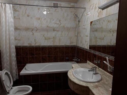 a bathroom with a tub and a sink and a toilet at Sky luxe-hotel Astana in Astana