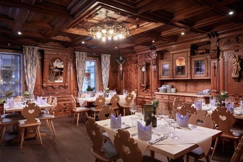 a dining room with tables and chairs and a chandelier at Hotel Neue Post in Mayrhofen