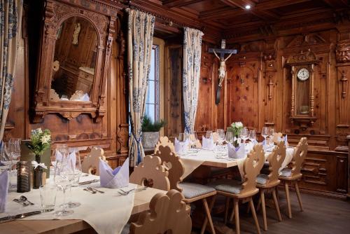 a dining room with tables and chairs and a clock at Hotel Neue Post in Mayrhofen