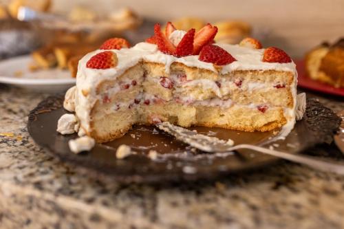 a piece of cake with strawberries on a plate at Hotel Heinz in Palhoça