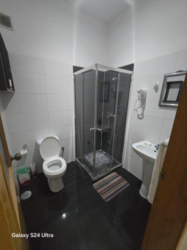 a bathroom with a shower and a toilet and a sink at My Flat 2 in Praia