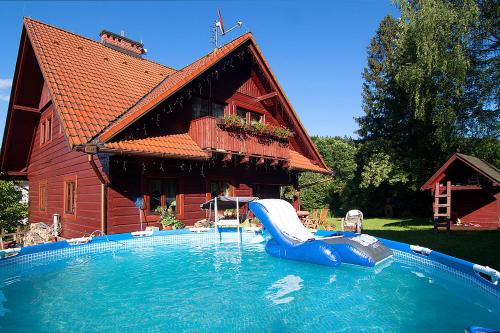 a swimming pool with a slide in front of a house at Chata Góralska Aggeusz in Wisła