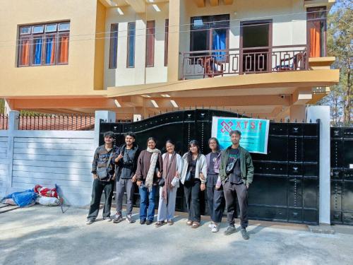a group of people standing in front of a building at XTSY Family Rooms & Dorms in Shillong