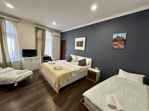 a hotel room with two beds and a television at Boutique Hotel Point in Tbilisi City