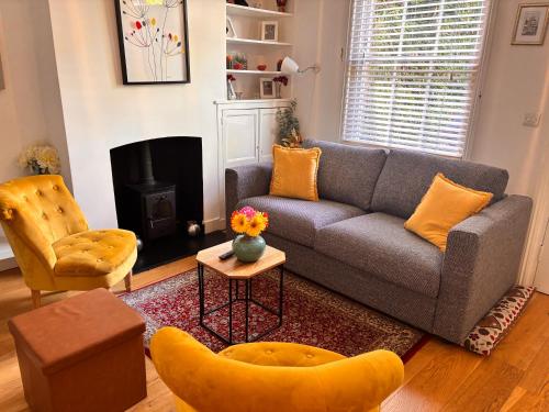 a living room with a couch and a chair at Elegant Riverside Cottage With Free Parking in Canterbury