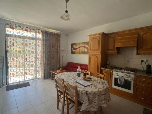 a kitchen with a table with chairs and a dining room at Charming Seaside Apartment in Mellieħa