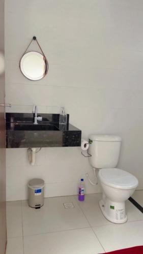 a bathroom with a toilet and a sink and a mirror at Viver de Temporada Canindé- 15 Minutos de Piranhas in Canindé de São Francisco