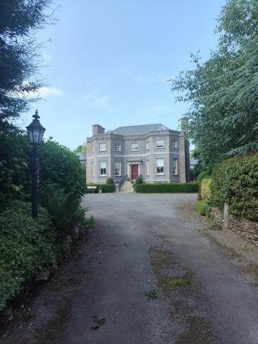 a large house with a driveway in front of it at Charlesfort House in Ferns