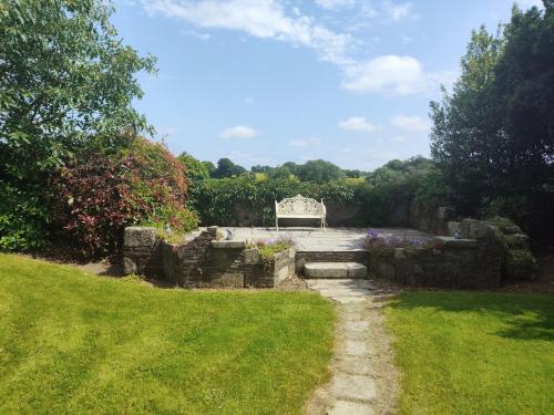 a garden with a bench in the middle of a yard at Charlesfort House in Ferns