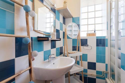 y baño con lavabo y paredes de azulejos azules y blancos. en Mar i Munt, en Banyuls-dels-Aspres