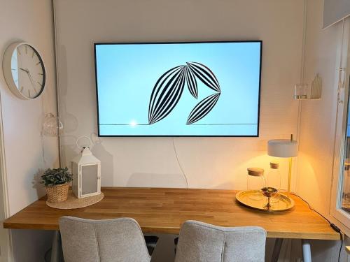 Un televisor de pantalla plana colgado en una pared encima de una mesa. en Ihana Helmi - The Nest for Two, en Vaasa