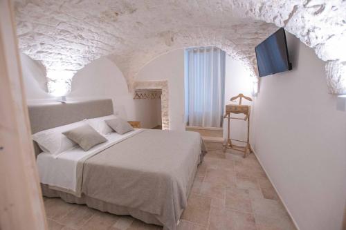 a bedroom with a bed in a room with white walls at Pregio Villas per Suite Oronzo Charme&Pool in Ostuni